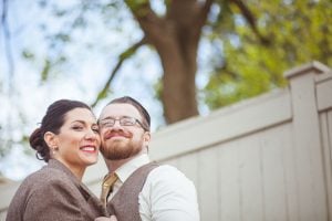 Bride wearing the groom's coat, sharing a romantic moment.