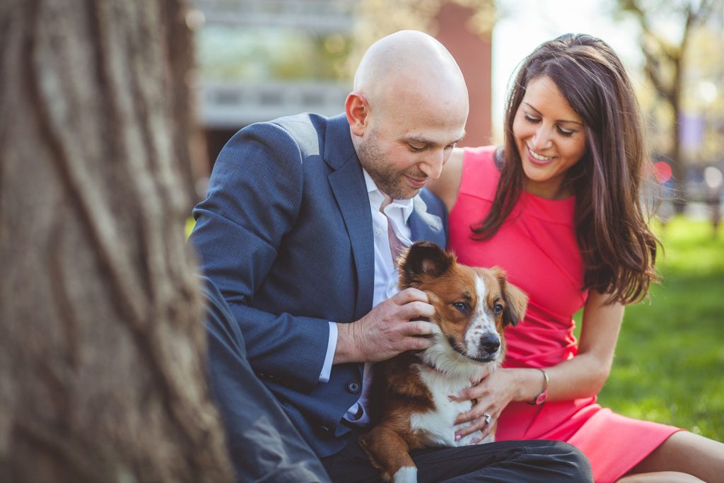 engaged couple playing with their dog.