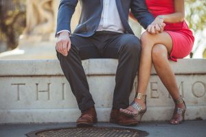 Engaged couple sit closely together.