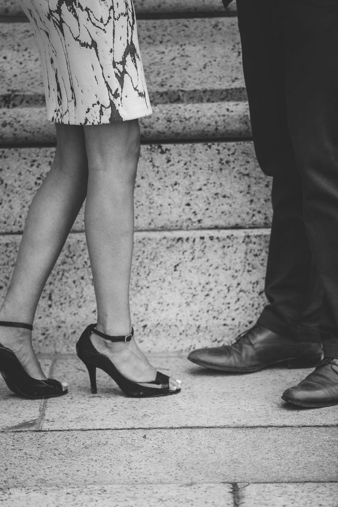 black and white photo of engaged couple's feet as they share a romantic moment.