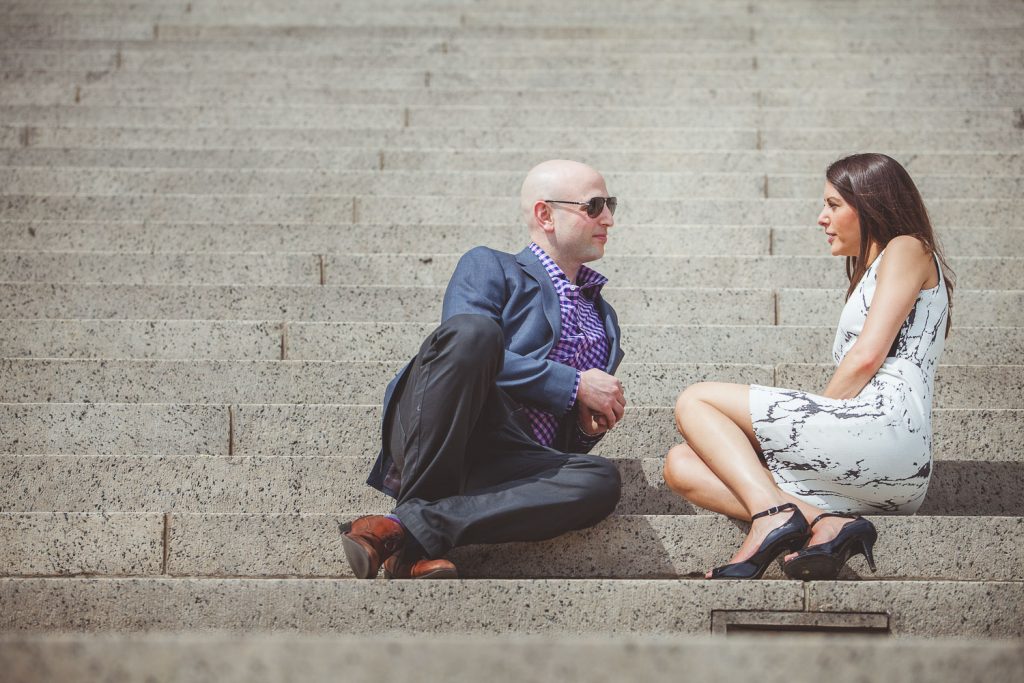 engaged couple having a discussion on the steps of the National Archives in DC