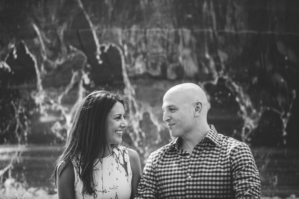 Black and white photo of an Engaged couple in front of a fountain in DC.