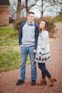 A newly engaged couple standing on a brick walkway in Downtown Annapolis.