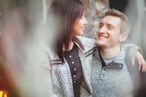 In downtown Annapolis, a man and woman are smiling at each other in front of a brick wall.