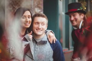 A man and woman are posing for a portrait in front of a Christmas tree.