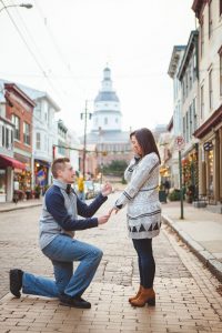 In Downtown Annapolis, a couple kneels down on a city street for an intimate marriage proposal.