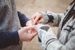 A couple sharing a beautiful portrait in Downtown Annapolis as they exchange rings, marking their joyful marriage proposal.