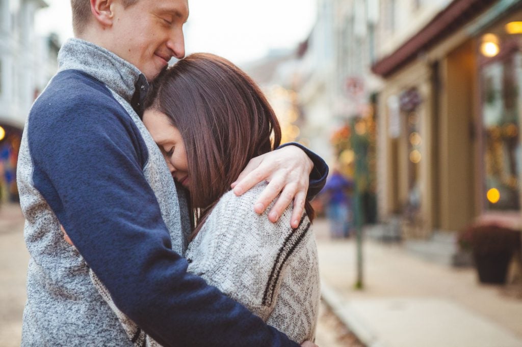 A man and woman sharing a tender portrait on a downtown street in Annapolis.