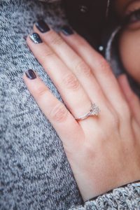 A woman with a ring on her finger, captured in a heartwarming Downtown Annapolis portrait.