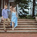 An engaged couple walking down the steps of a brick building in Downtown Annapolis, capturing a beautiful Engagement Photo.