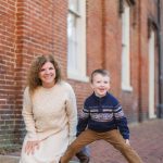 A family poses in front of a brick building in downtown Annapolis.