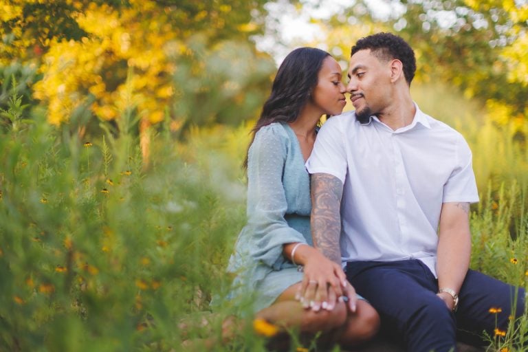 A couple sitting in Quiet Waters Park during their engagement session.