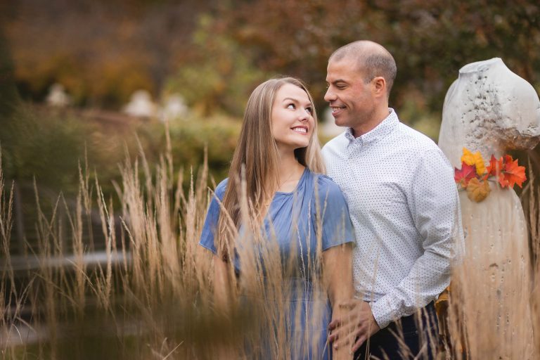 An engaged couple standing in tall grass at Quiet Waters Park, Maryland.