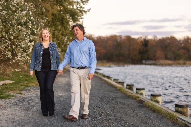 A couple holding hands on a path near Quiet Waters Park in Annapolis, Maryland.