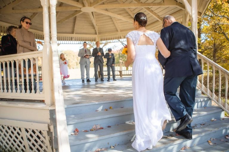 A bride and groom walking down the steps of a gazebo at Quiet Waters Park in Annapolis, Maryland.