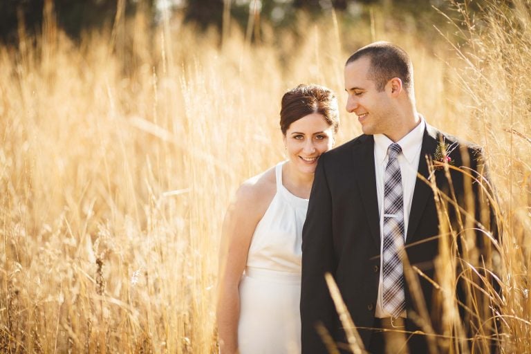 A bride and groom standing in the tall grass at Quiet Waters Park in Annapolis, Maryland.