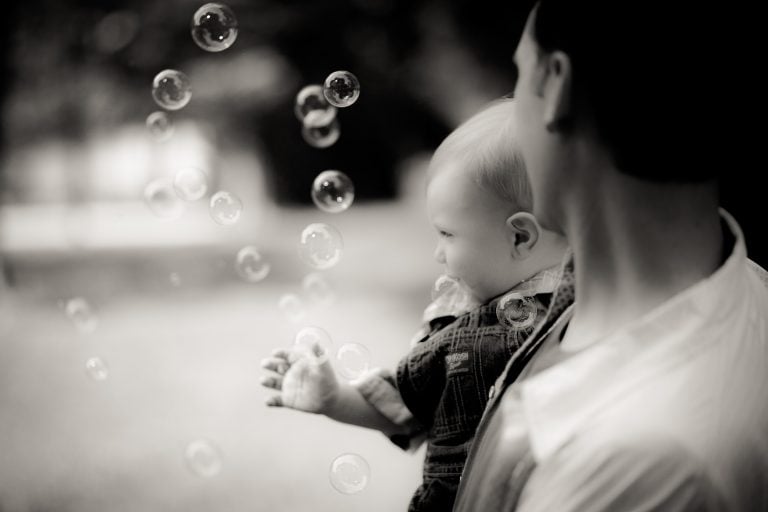 A black and white photo of a man holding a baby in Allen Pond, Maryland.