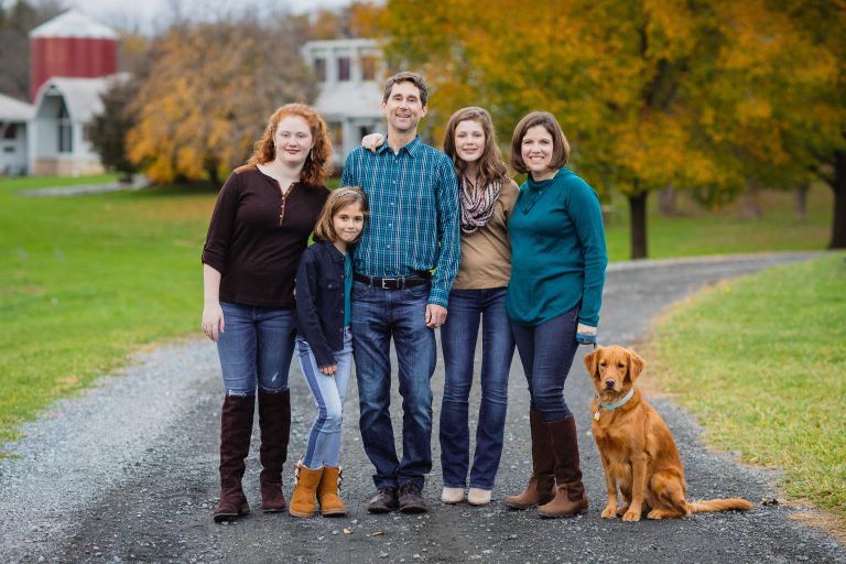 A family posing for a photo in front of Derwood's Agricultural History Farm Park.