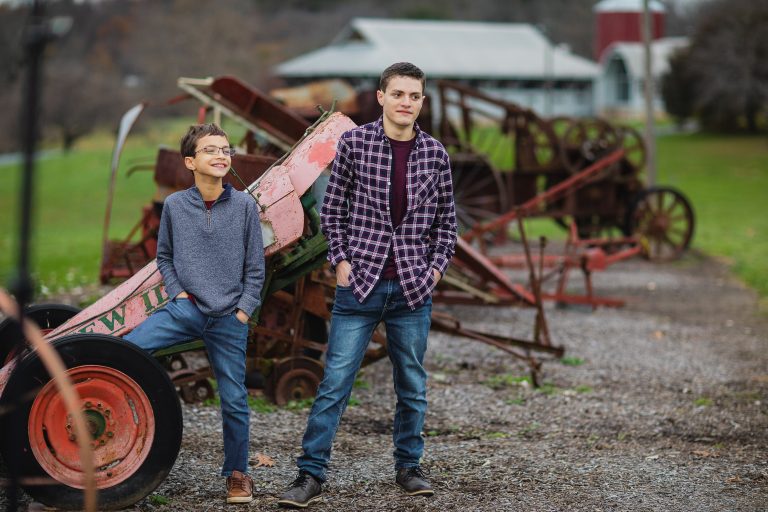 Two boys standing in front of an old tractor at Agricultural History Farm Park in Derwood, Maryland.