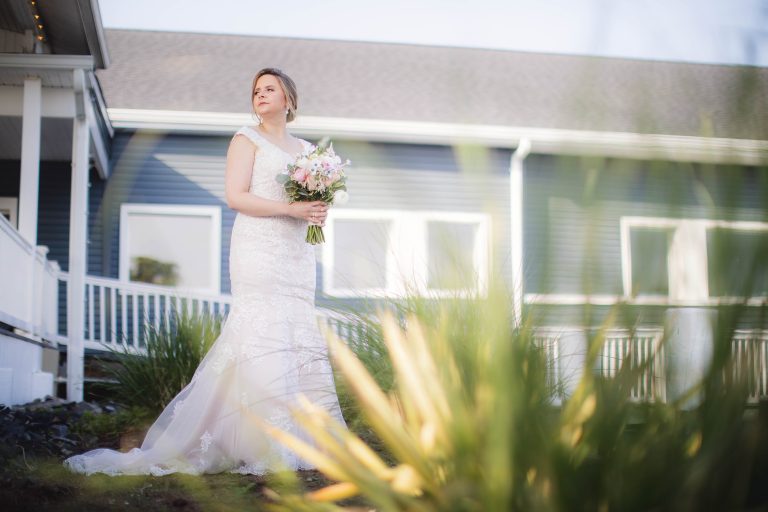 A bride in a wedding dress standing in front of a house in Annapolis, Maryland.