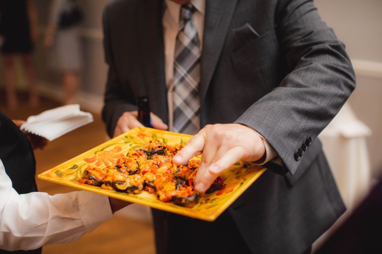 A man in a suit holding a plate of food at the Anchor Inn in Annapolis, Maryland.