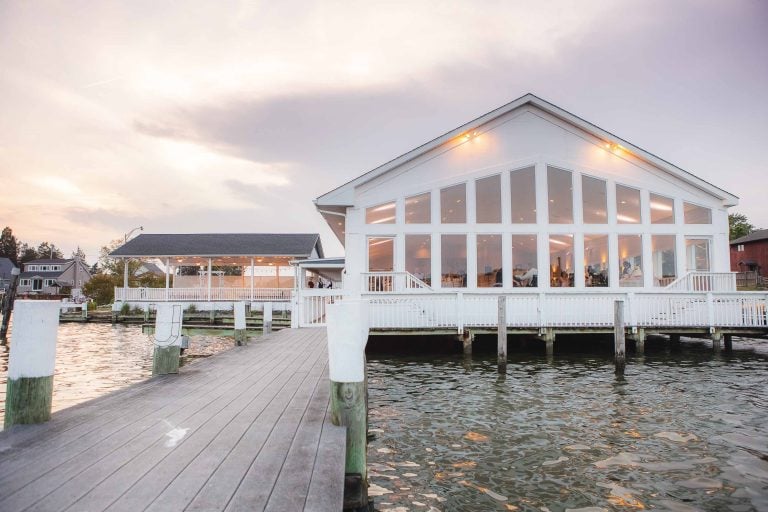 A white house with a dock on the water in Annapolis, Maryland.