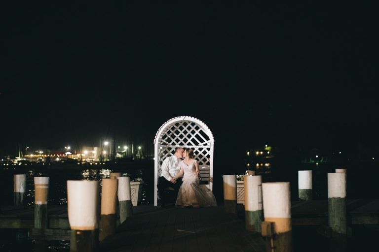 A bride and groom standing on a dock at the Anchor Inn in Annapolis, Maryland.