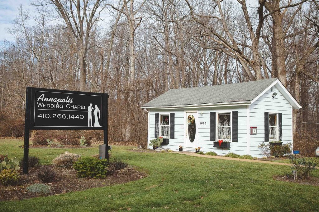 An adorable small house with a sign in front of it, located in Annapolis just moments away from the Maryland capital, Annapolis Wedding Chapel.