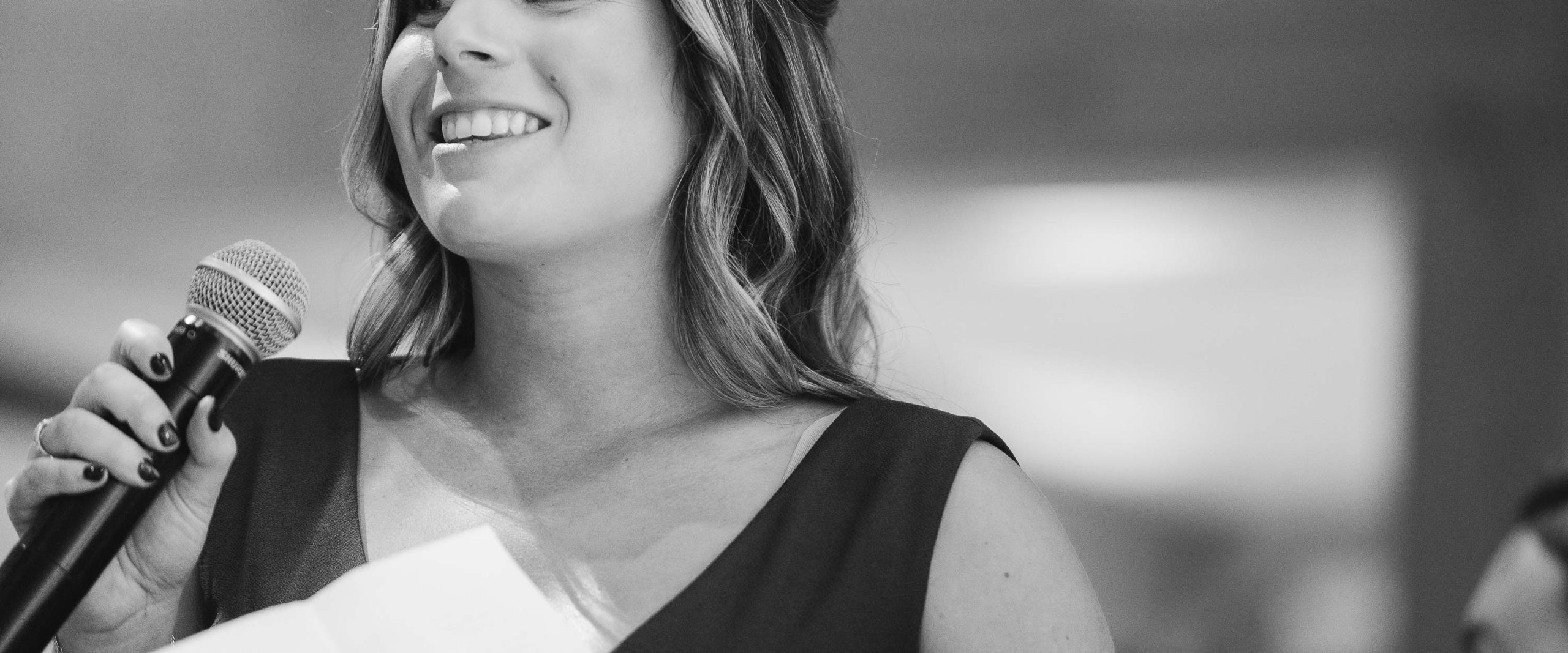 A woman is holding a microphone and smiling in Annapolis, Maryland.