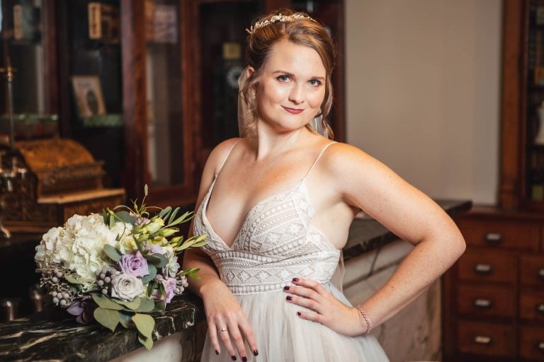 A bride in a wedding dress posing in front of a bar at the Baltimore Museum of Industry.