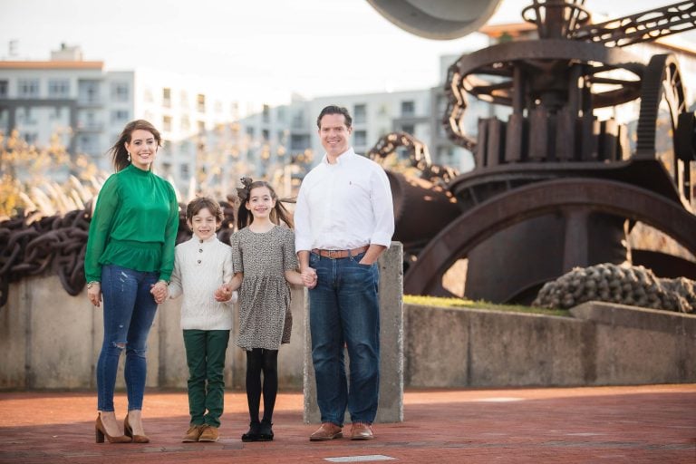 A family is posing for a photo in front of the Baltimore Museum of Industry.