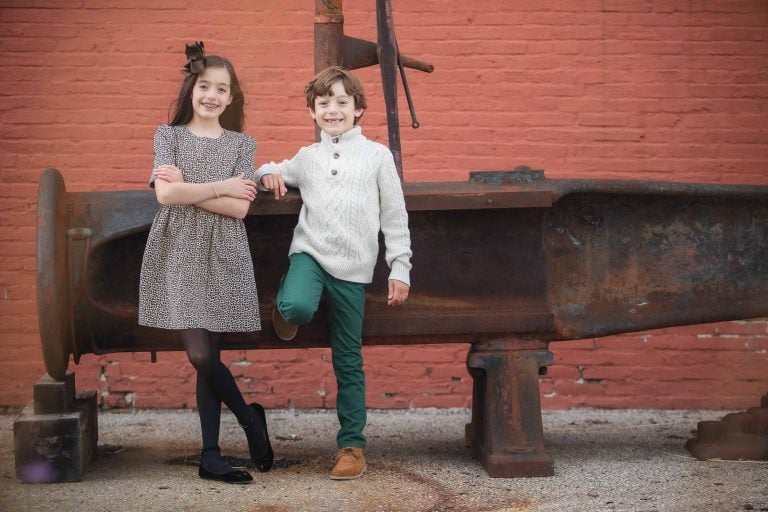 Two children posing in front of a red brick wall at Baltimore Museum of Industry (Outdoors).