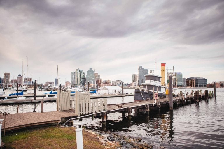 A boat docked at Baltimore with a city skyline in the background.