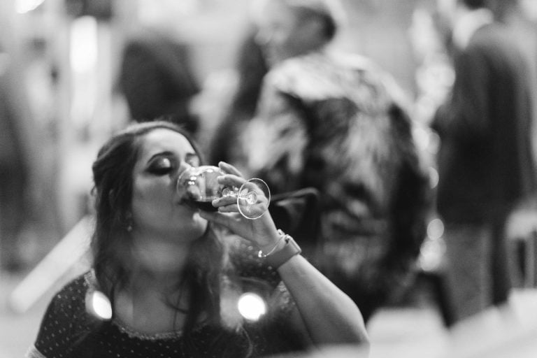 A woman drinking a glass of water at a party at Hamilton.