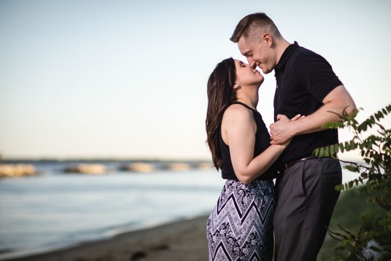 A couple kisses on the beach at Beverly Triton Nature Park during their engagement session.