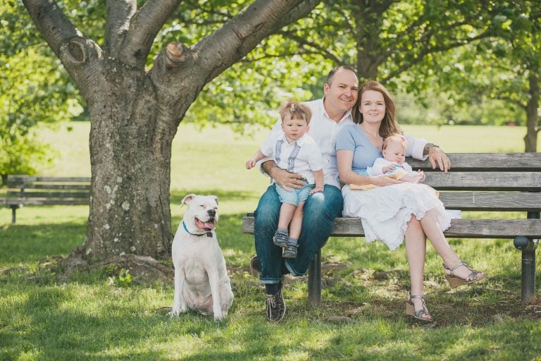 A family sits on a park bench in Germantown, Maryland with their dog at Black Hill Regional Park.