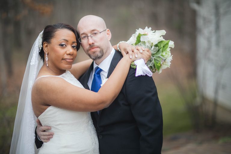 A bride and groom hugging in front of Dorsey Chapel in Maryland.