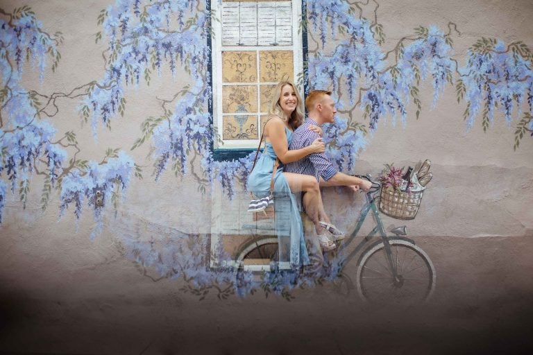 A man and woman sitting on a bicycle in Downtown Annapolis.