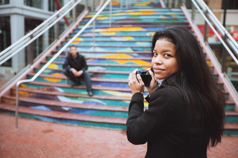 A woman is taking a picture of herself in front of a colorful staircase in Downtown Silver Spring, Maryland.