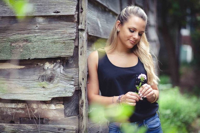 A young woman holding a flower at Elkridge Furnace Inn in Elkridge, Maryland.