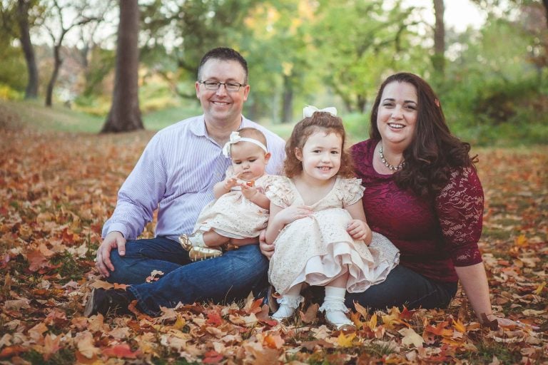 A family sits on the ground in Fort Ward Park.