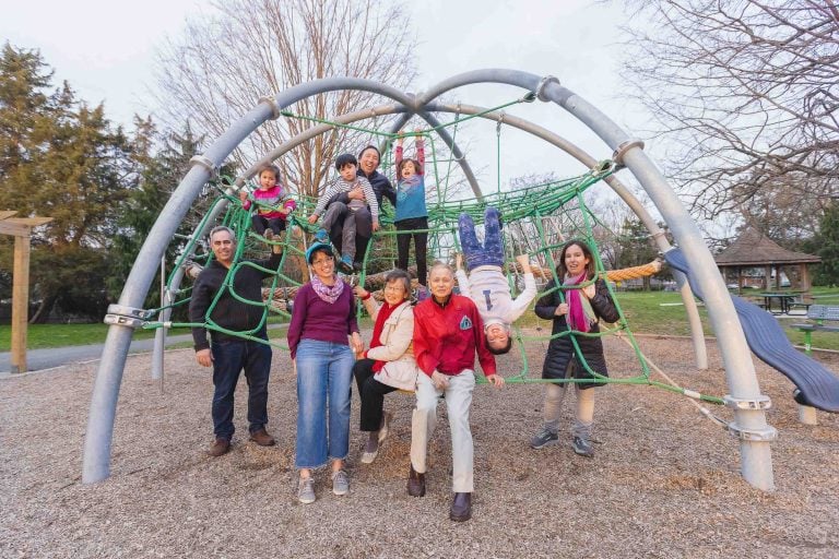 A group of people posing in front of a playground structure at General Getty Neighborhood Park.