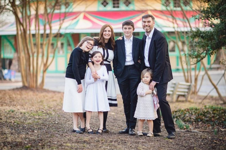 A family posing for a photo in front of Glen Echo Park carousel.