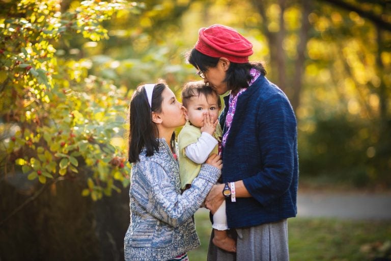 A family is holding a baby in their arms at Glen Echo Park in Maryland.