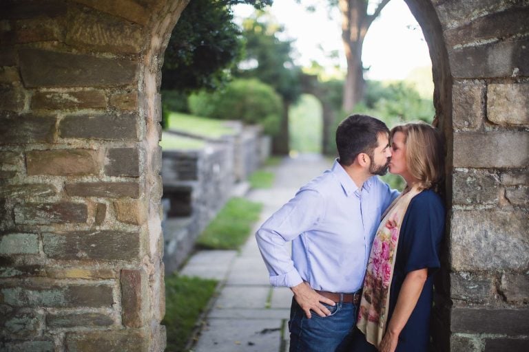 An engaged couple kissing at Glenview Mansion in Rockville, Maryland.