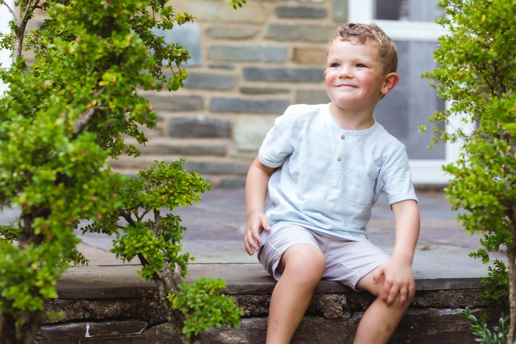 A young boy sitting on the steps of Glenview Mansion in Rockville, Maryland.