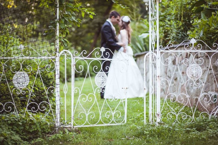 A bride and groom standing in front of the Gramercy Mansion in Maryland.