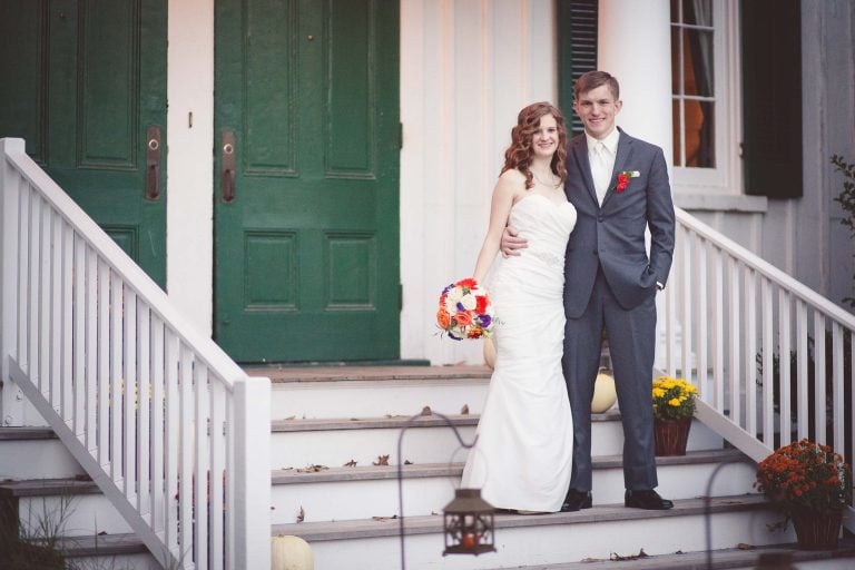 A bride and groom standing on the steps of Historic Baldwin Hall in Maryland, Millersville.