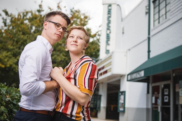 A couple embracing in front of the Old Greenbelt Theatre in Greenbelt, Maryland.