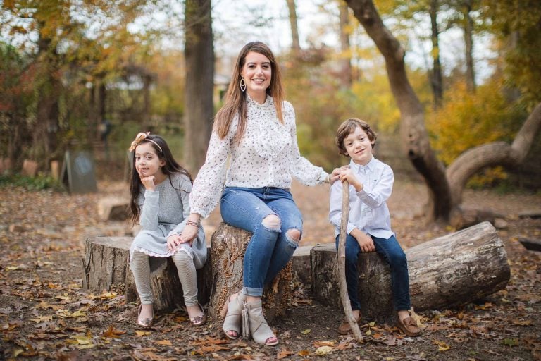 Families sit on a log in the wooded area of Owings Mills, Maryland near Irvine Nature Center.